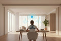 Person wearing a back brace at a desk with a bell icon above, indicating alerts or notifications.