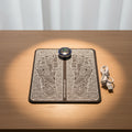 Foot massage mat with black and white design and USB cable on a white background
