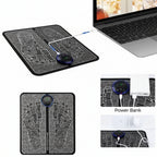 Black charging mat with USB ports, power bank, and phone charger attachments, displayed with a laptop.
